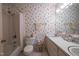 Bathroom featuring a shower-tub combo, double sinks, and patterned wallpaper at 114 Montrose Dr # 114, Durham, NC 27707