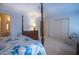Cozy bedroom features a four-poster bed, a dresser with a lamp, and a large closet at 114 Montrose Dr # 114, Durham, NC 27707