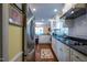 Well-lit kitchen with white cabinetry, dark granite countertops, stainless steel appliances, and decorative rug at 114 Montrose Dr # 114, Durham, NC 27707