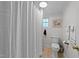 Bathroom with white shower curtain, toilet, and light brown tile flooring at 116 Lakewood Dr, Wendell, NC 27591