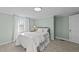 Comfortable bedroom features neutral carpet, light green walls, and natural light from window at 116 Lakewood Dr, Wendell, NC 27591
