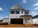 Two-story home featuring white siding, black trim, an attached garage, and a well-manicured lawn at 118 Fairwinds Drive Dr, Lillington, NC 27546