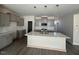 Bright, modern kitchen with gray cabinets, a large island with a sink, and pendant lighting at 118 Fairwinds Drive Dr, Lillington, NC 27546