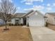 Charming single-story home featuring a two-car garage, landscaped yard, and light gray vinyl siding at 1207 Bluewater Way, Durham, NC 27703