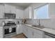 Well-lit kitchen featuring white cabinets, stainless steel appliances, and granite countertops at 1207 Bluewater Way, Durham, NC 27703