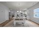 Bright eat-in kitchen features white cabinets, stainless steel appliances, and a farmhouse dining table at 1207 Bluewater Way, Durham, NC 27703