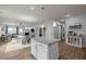 Open-concept living space with kitchen island, dining area, and cozy living room with fireplace at 1207 Bluewater Way, Durham, NC 27703