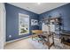 Stylish home office with blue walls, hardwood floors, and a well-lit desk area with backyard views at 1207 Bluewater Way, Durham, NC 27703