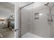 Tiled shower with glass door, integrated shelving, and a rainfall shower head, offering a spa-like experience at 1207 Bluewater Way, Durham, NC 27703