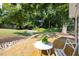 Inviting backyard with a wooden deck featuring a table and chair set, lush lawn, and mature trees at 122 W Union St, Hillsborough, NC 27278