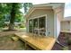 Relaxing backyard with a wooden deck, table and chairs, mature trees, and a rock feature at 122 W Union St, Hillsborough, NC 27278