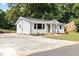 Exterior elevation of a gray home that includes an asphalt driveway and landscaped yard at 122 W Union St, Hillsborough, NC 27278