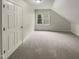 Attic features neutral carpet and a window to let in natural light at 12316 Amoretto Way, Raleigh, NC 27613