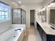 Bathroom featuring double sinks, soaking tub with glass shower enclosure, and natural light for a relaxing spa-like experience at 12316 Amoretto Way, Raleigh, NC 27613