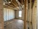 View of wood frame bedroom with fiberglass insulation and window at 129 Grace Pond Ave, Benson, NC 27504