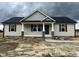 Charming single-story home with beige siding, a covered front porch, and a dark roof at 129 Grace Pond Ave, Benson, NC 27504