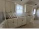 Bright kitchen area with white cabinets, modern fixtures, and a window, still under construction and covered in plastic at 129 Grace Pond Ave, Benson, NC 27504