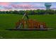 Fun community playground with slides and climbing features set against a backdrop of lush greenery and sky at 1300 Hazelnut Ridge Ln, Knightdale, NC 27545