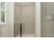 Modern shower with glass door, neutral tile, and a convenient bench seat at 1300 Hazelnut Ridge Ln, Knightdale, NC 27545