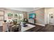 Stylish living room with a decorative accent wall, large windows offering natural light, and hardwood floors at 1304 Hazelnut Ridge Ln, Knightdale, NC 27545