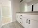 Bathroom featuring a white vanity with black hardware, a large mirror, and tile flooring at 1309 Sanctuary Pond Dr, Raleigh, NC 27603