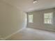 Bedroom with neutral walls, two windows for natural light, and carpeted floors at 1309 Sanctuary Pond Dr, Raleigh, NC 27603
