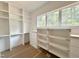 Walk-in closet with white shelving and drawers with a window for natural light at 1309 Sanctuary Pond Dr, Raleigh, NC 27603