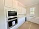 Kitchenette featuring white cabinets, stainless steel appliances, and ample counter space at 1309 Sanctuary Pond Dr, Raleigh, NC 27603