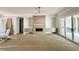 Spacious living room featuring a ceiling fan, fireplace, and sliding doors leading to the outdoor patio at 1309 Sanctuary Pond Dr, Raleigh, NC 27603