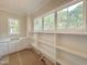 Walk-in pantry featuring white shelves, cabinets, counter space, and a window at 1309 Sanctuary Pond Dr, Raleigh, NC 27603