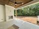 Covered patio featuring a stone fireplace, tile flooring and wooded backyard view at 1309 Sanctuary Pond Dr, Raleigh, NC 27603