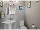 The bathroom has a pedestal sink, decorative mirror and soft gray walls at 150 Lystra Ridge Rd, Chapel Hill, NC 27517