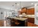 A gourmet kitchen features a large granite island with pendant lighting and custom wood cabinets at 150 Lystra Ridge Rd, Chapel Hill, NC 27517
