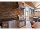 Outdoor kitchen with stainless steel grill, stone countertops, and convenient storage at 150 Lystra Ridge Rd, Chapel Hill, NC 27517