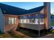 Back of house showcasing cozy screened-in porch and stone fireplace for relaxing evenings at 150 Lystra Ridge Rd, Chapel Hill, NC 27517