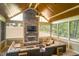 Comfortable sunroom with a stone fireplace, sectional sofa, ceiling fan, and view of backyard at 150 Lystra Ridge Rd, Chapel Hill, NC 27517