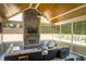 Cozy sunroom with a stone fireplace, sectional sofa, ceiling fan, and many windows to let in sunlight at 150 Lystra Ridge Rd, Chapel Hill, NC 27517