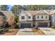 Inviting townhome featuring a brick and siding exterior, two-car garage, and a paved driveway at 154 Alamosa Pl, Cary, NC 27519
