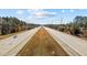 A wide highway with multiple lanes stretches into the horizon, surrounded by lush greenery and clear blue skies at 154 Alamosa Pl, Cary, NC 27519