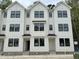 Modern townhome complex featuring white siding, black window trim, and symmetrical design elements at 1543 Crescent Townes Way, Raleigh, NC 27604