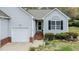 Charming light blue house featuring a well-manicured garden, single-car garage, and brick accents at 1808 W Cotton Gin Dr, Clayton, NC 27527
