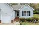 Inviting front entrance with red brick steps, light-gray siding, and well-maintained landscaping at 1808 W Cotton Gin Dr, Clayton, NC 27527