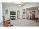 Spacious living room featuring plush carpeting, a ceiling fan, and a television for relaxing and entertaining at 1808 W Cotton Gin Dr, Clayton, NC 27527