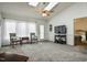 Bright living room featuring carpet, a ceiling fan, and natural light from a door and window at 1808 W Cotton Gin Dr, Clayton, NC 27527