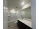 This bathroom features a shower over tub, a mirror, and dark cabinets at 190 Chestnut Oak Ln, Lillington, NC 27546