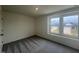 This bedroom has gray carpet, white walls, and a view from the window at 190 Chestnut Oak Ln, Lillington, NC 27546