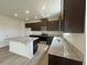 Modern kitchen featuring dark cabinets, stainless steel appliances, and a large island at 190 Chestnut Oak Ln, Lillington, NC 27546