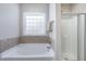 Bathroom featuring a soaking tub and glass-enclosed shower at 191 W Cultivator Way, Clayton, NC 27520