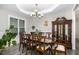Formal dining room with elegant chandelier, large windows, and hardwood floors at 191 W Cultivator Way, Clayton, NC 27520