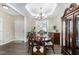 Formal dining room with elegant chandelier, large windows, and hardwood floors at 191 W Cultivator Way, Clayton, NC 27520